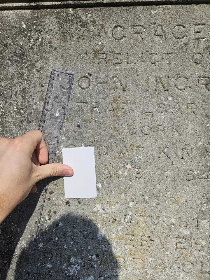 A reference card held flat beside lettering using one thumb