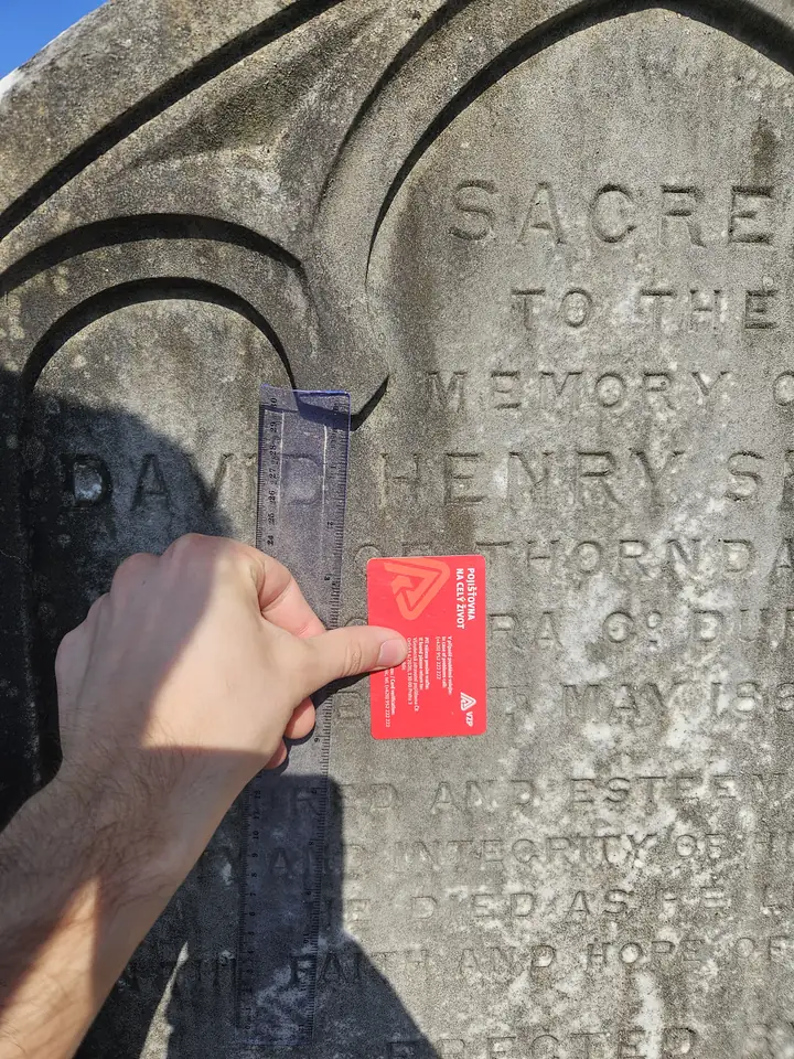 A square-on gravestone photo with the card and lettering clearly visible